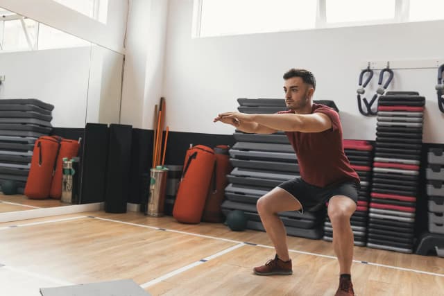 A man performing a body weight squat