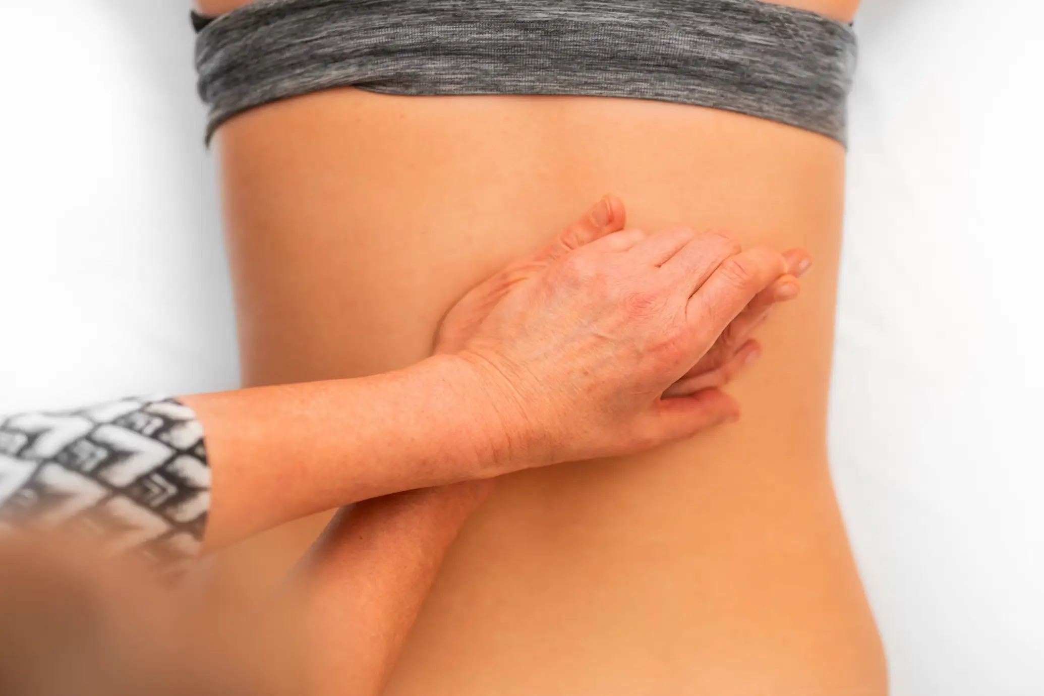 A woman receiving massage treatment on her lower back